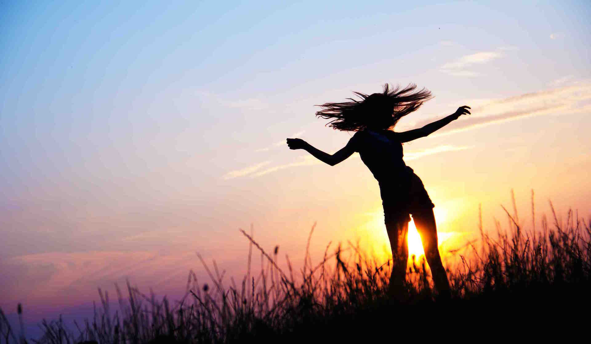Woman dancing in the medow, sunrise