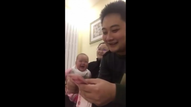 Bebé no aguanta la risa mientras su papá cuenta dinero