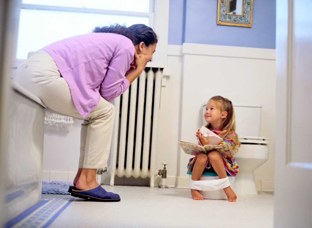 Girl Reading a Book on a Potty Chair