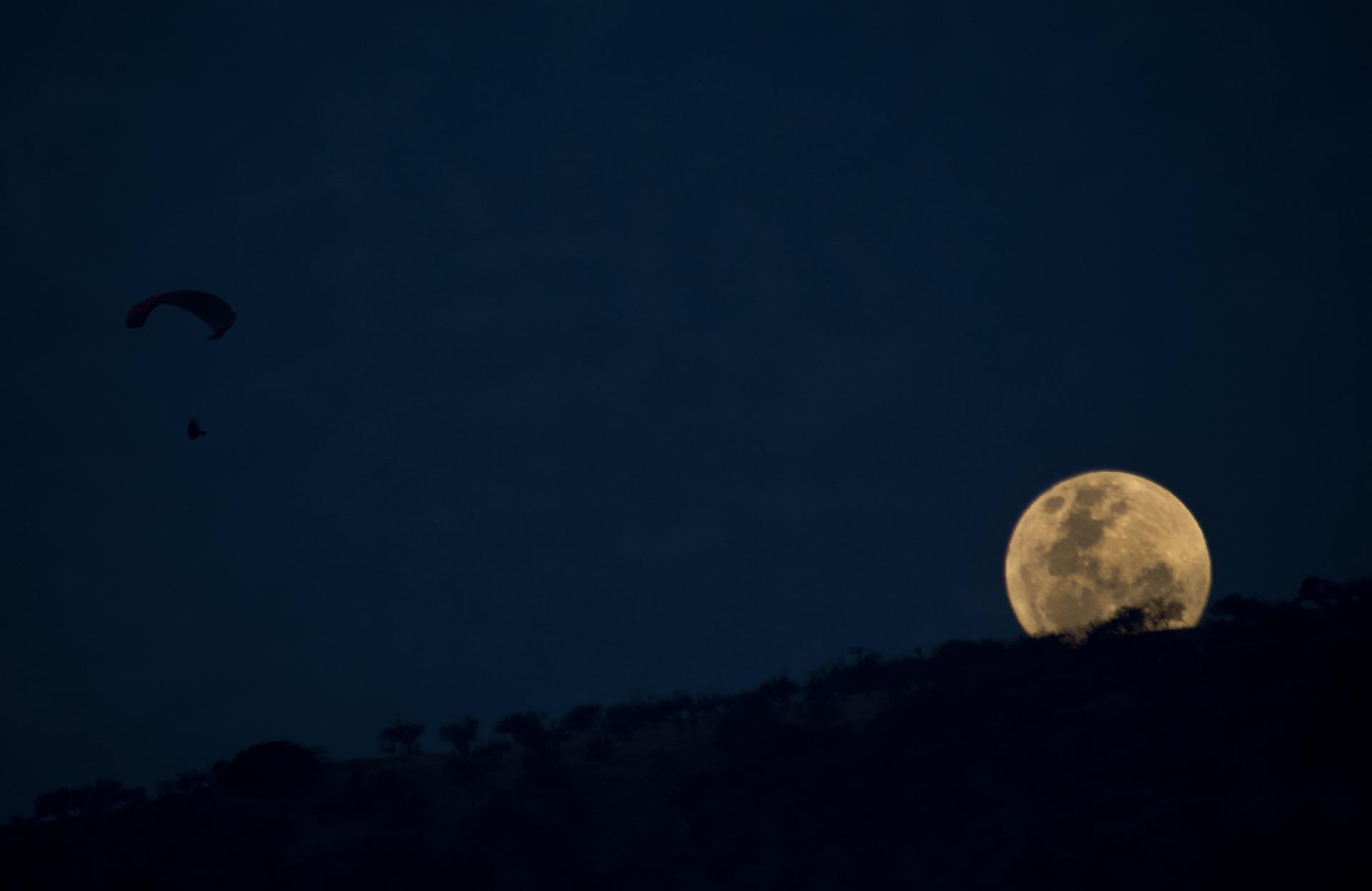 An unusually large and bright Moon -the closest "supermoon" to Earth in 68 years- adorns the night sky in Santiago on November 13, 2016. / AFP PHOTO / MARTIN BERNETTI