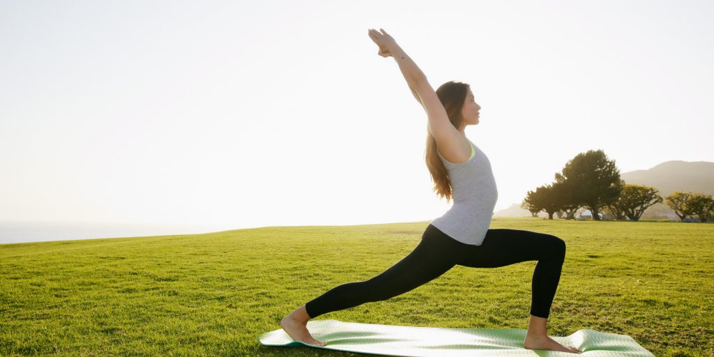 Mixed race woman practicing yoga in park