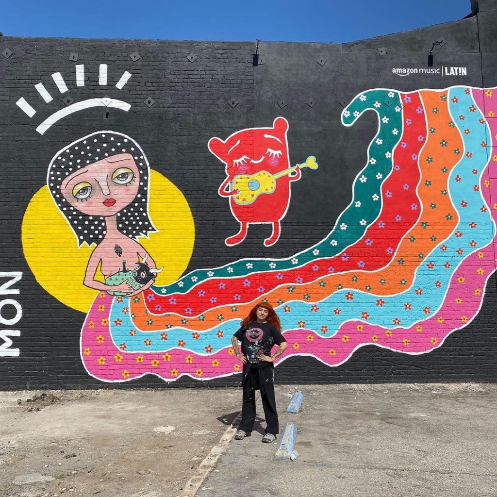 Mon Laferte junto al mural que realizó