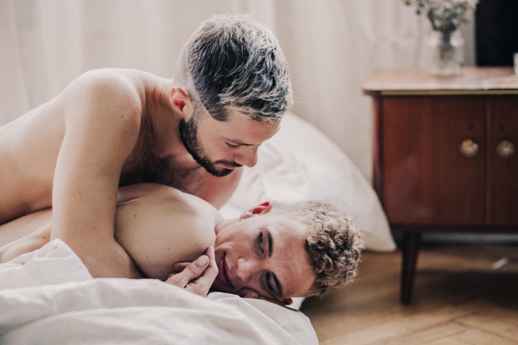 Gay Couple Embracing In Bed