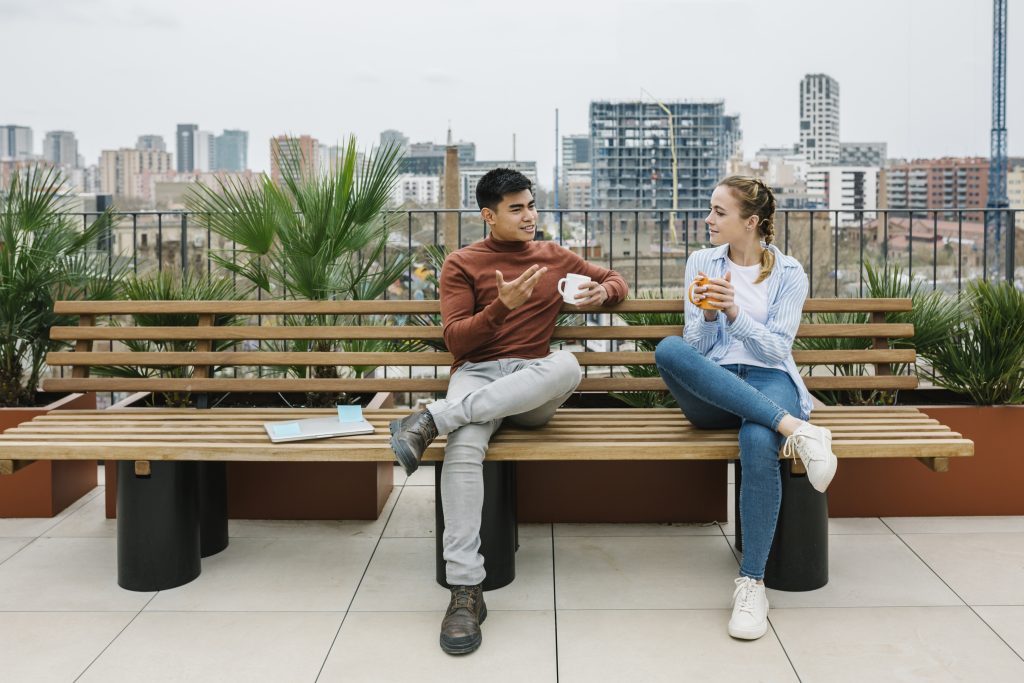 Male And Female Entrepreneurs Discussing While Having Coffee At Rooftop