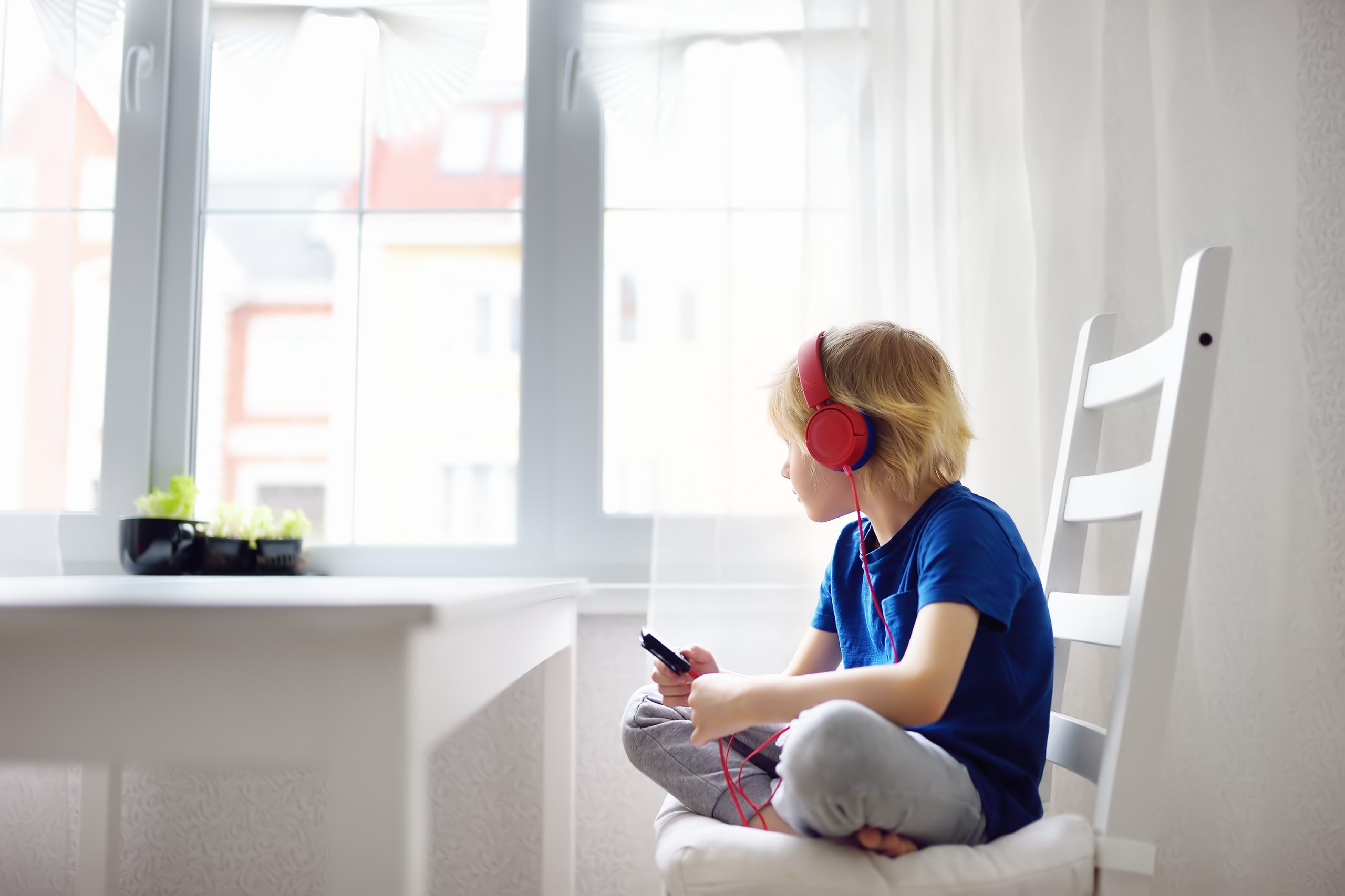 Preschooler Child Enjoy Listen Music Or Audiobook Using His Headphones At Home.