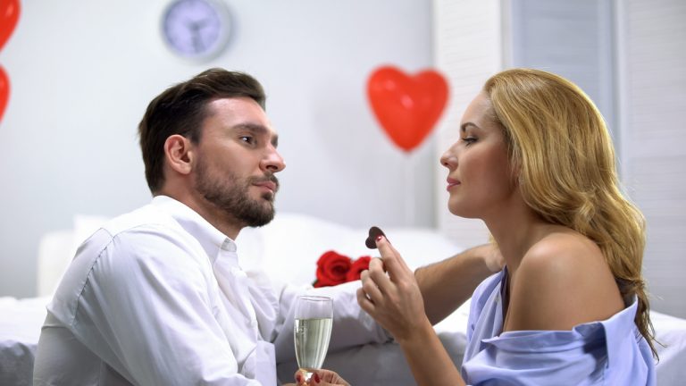 Couple Having Foreplay, Eating Chocolate And Drinking Champagne, Enjoying Time