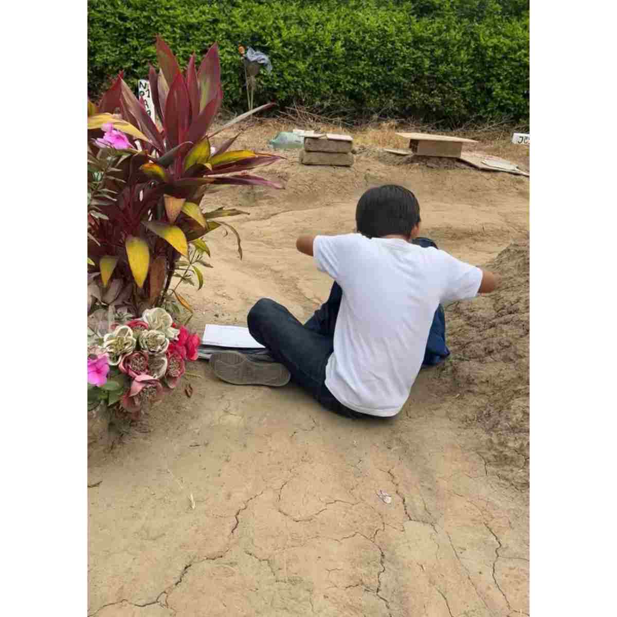 Niño visita la tumba de su madre. 
